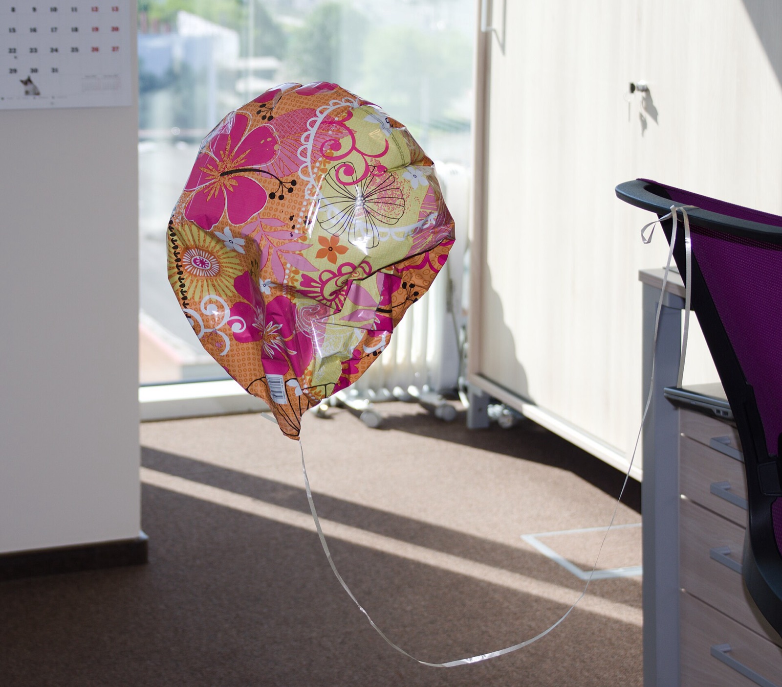 A wrinkled, half-deflated foil balloon that has gone soft and sunk after a few days.