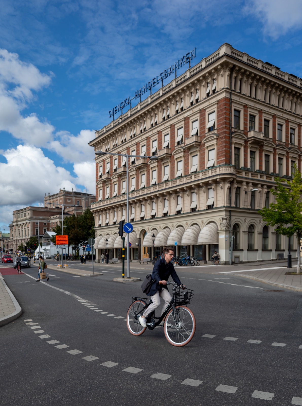 A person riding a bicycle along a city street, balancing easily while moving.