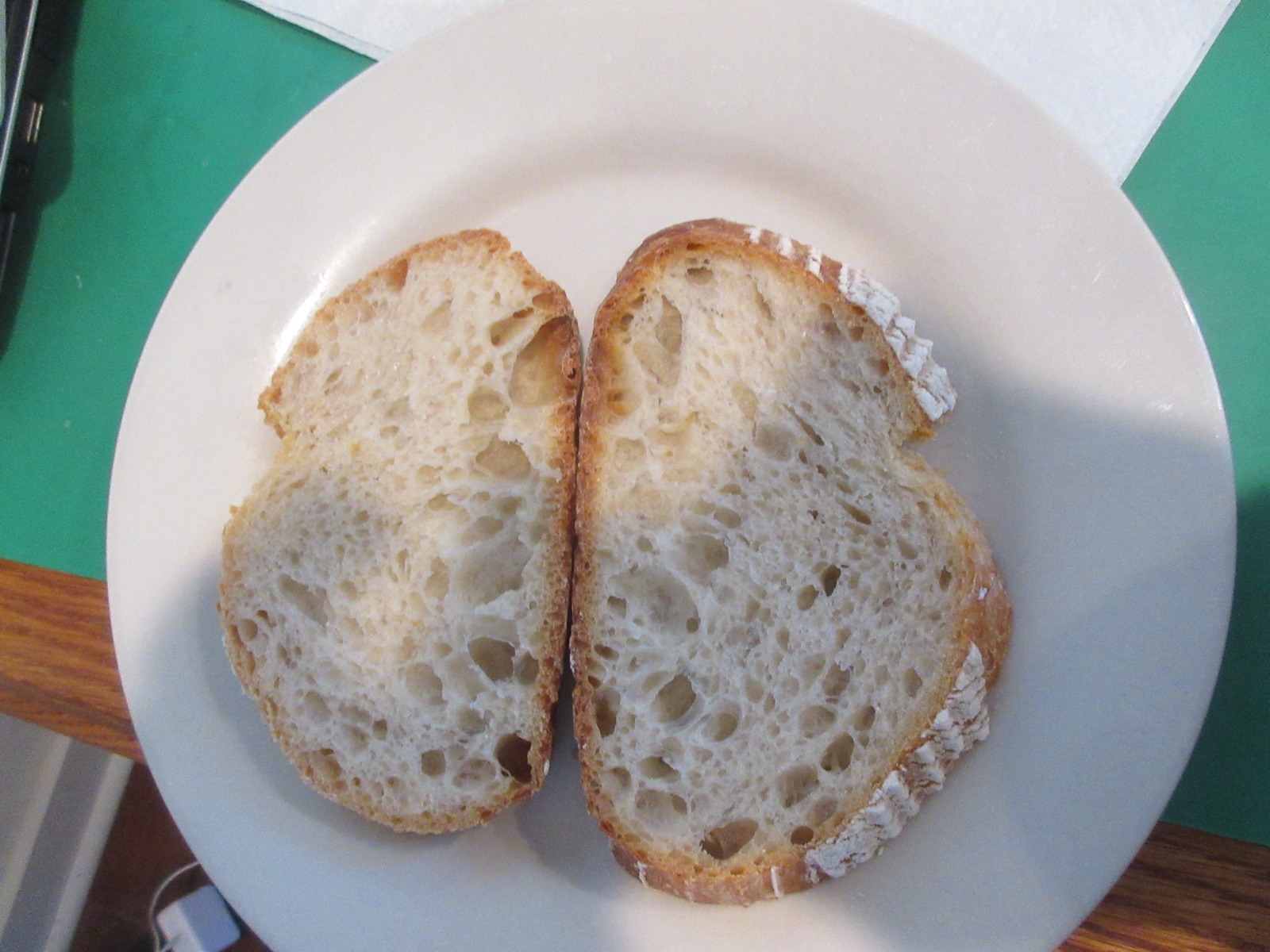 Two slices of crusty bread showing an airy crumb full of holes left by trapped gas