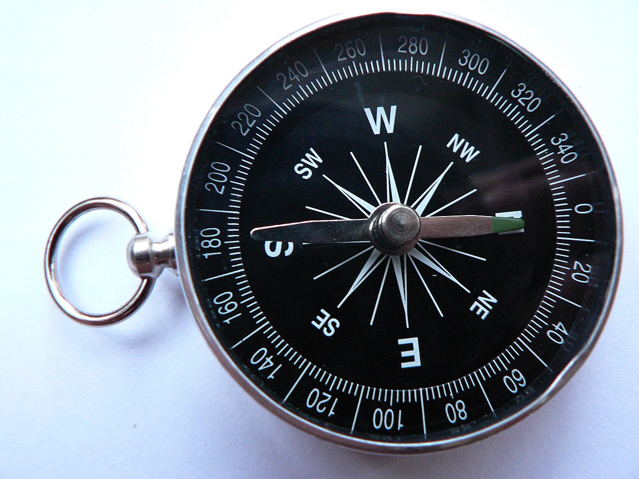 A magnetic compass, its needle settling toward north.