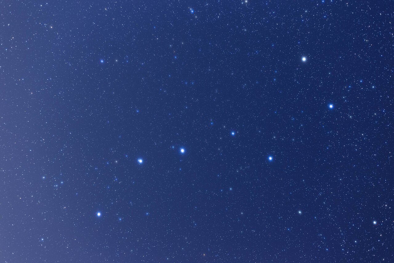 The seven bright stars of the Plough, or Big Dipper, standing out against a deep blue star-filled sky