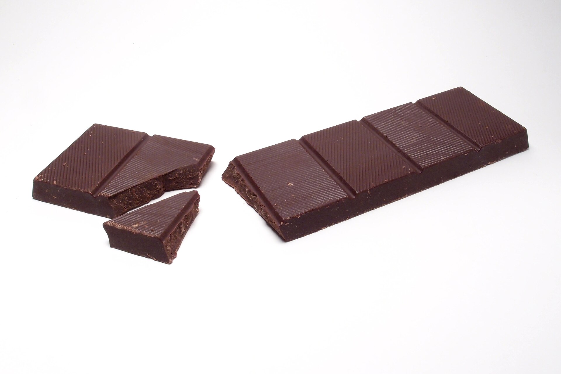 A bar of dark chocolate with a few pieces broken off it