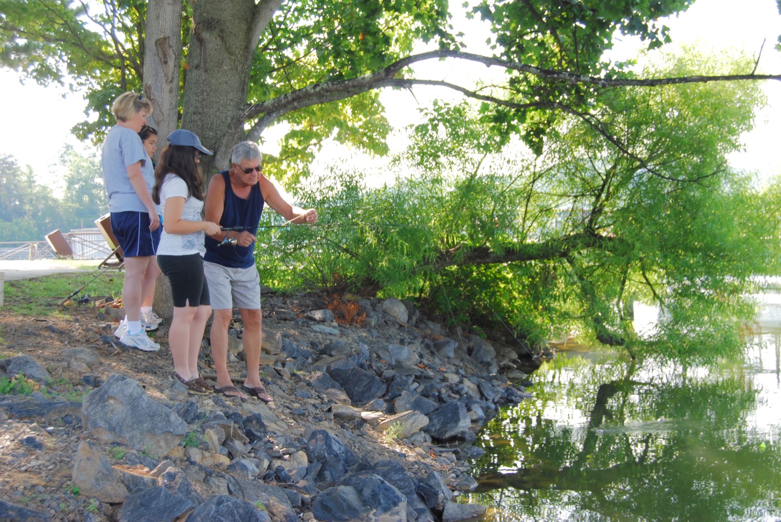 A family of several generations together outdoors by a lake, a community looking after one another.