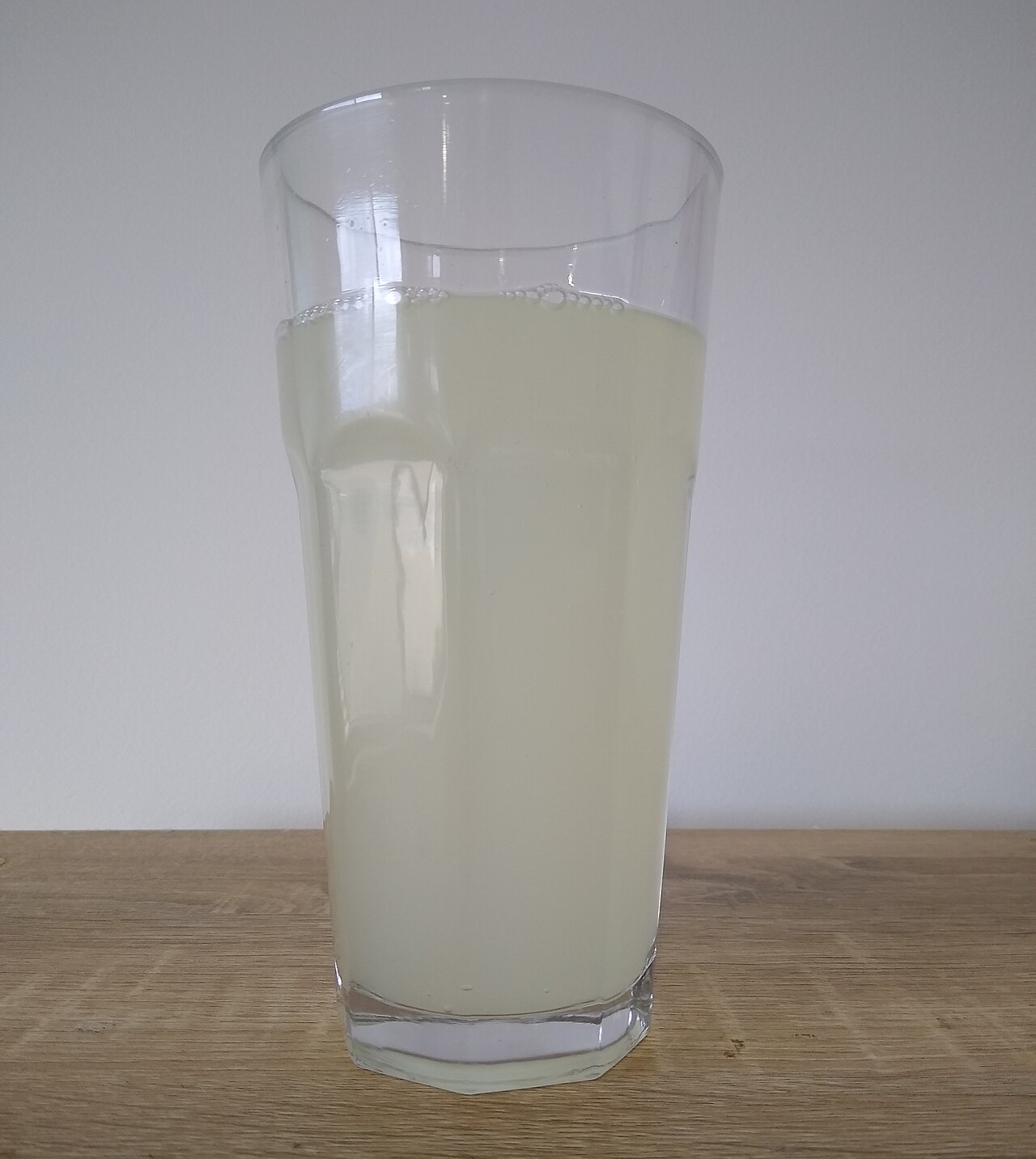A glass of fizzy soft drink full of rising bubbles