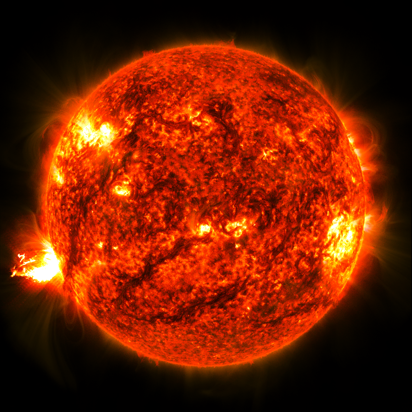 The full disk of the Sun with a bright solar flare erupting from one edge