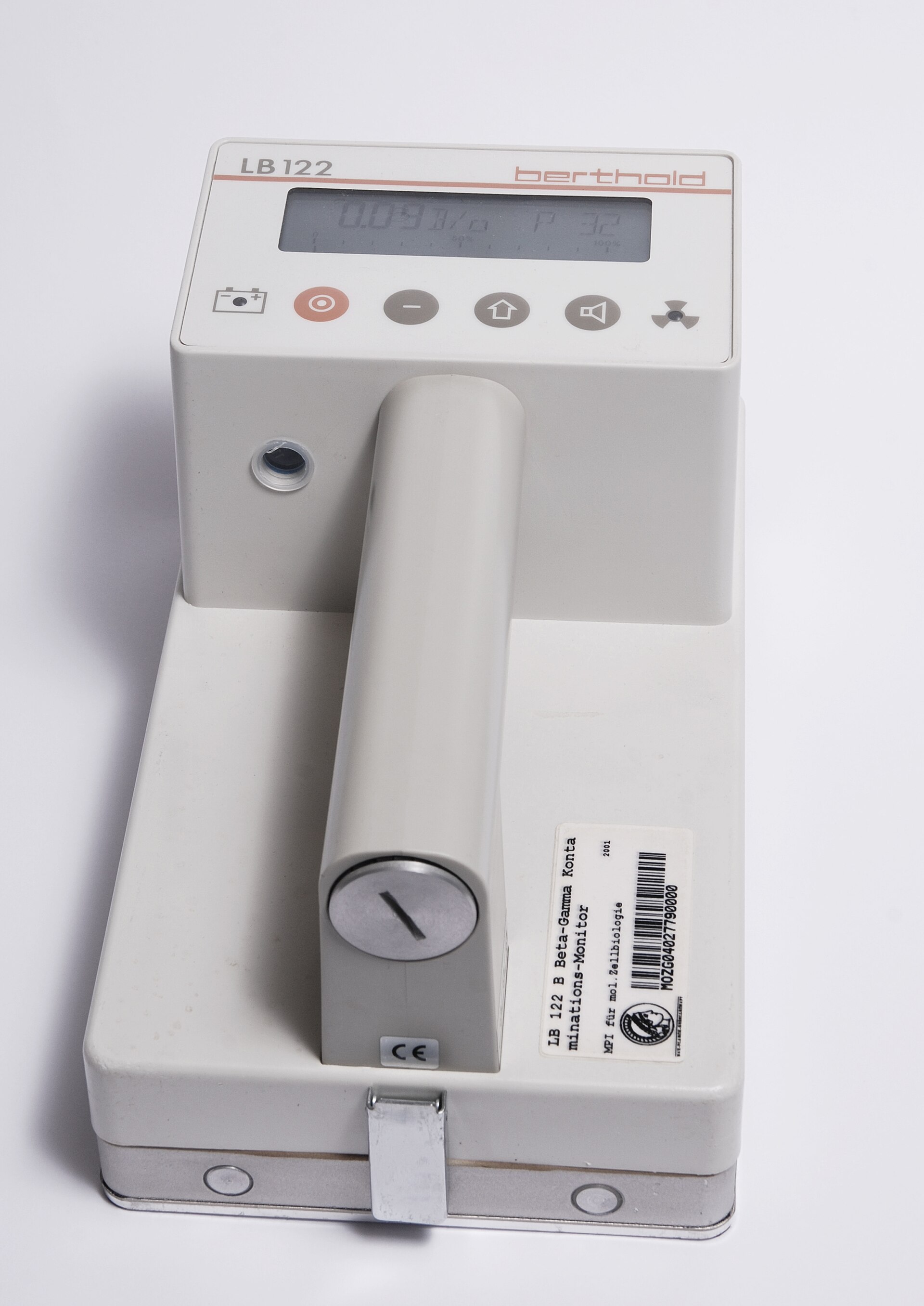 A handheld Geiger counter with its dial and probe, the instrument that clicks when it catches the invisible bursts atoms give off