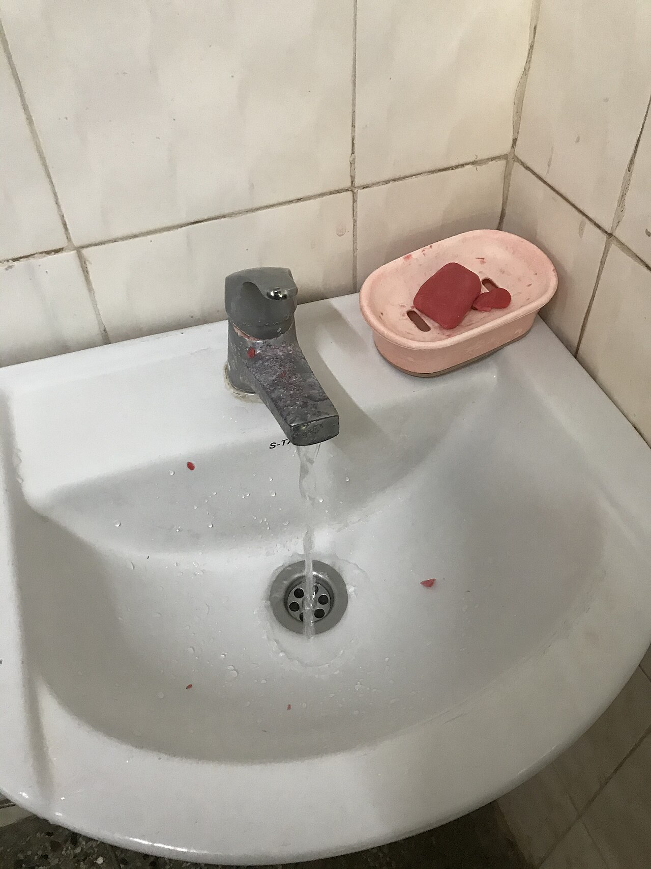 Hands being washed with soap under a running tap