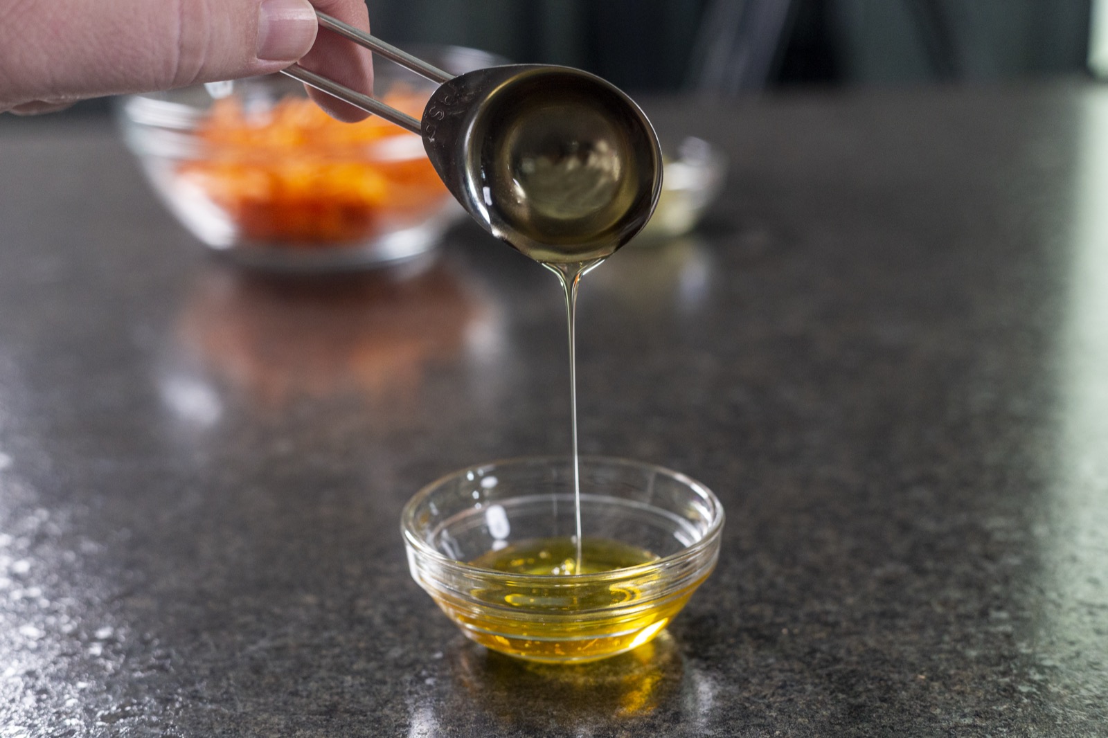 Honey being poured in a slow, thick golden ribbon.