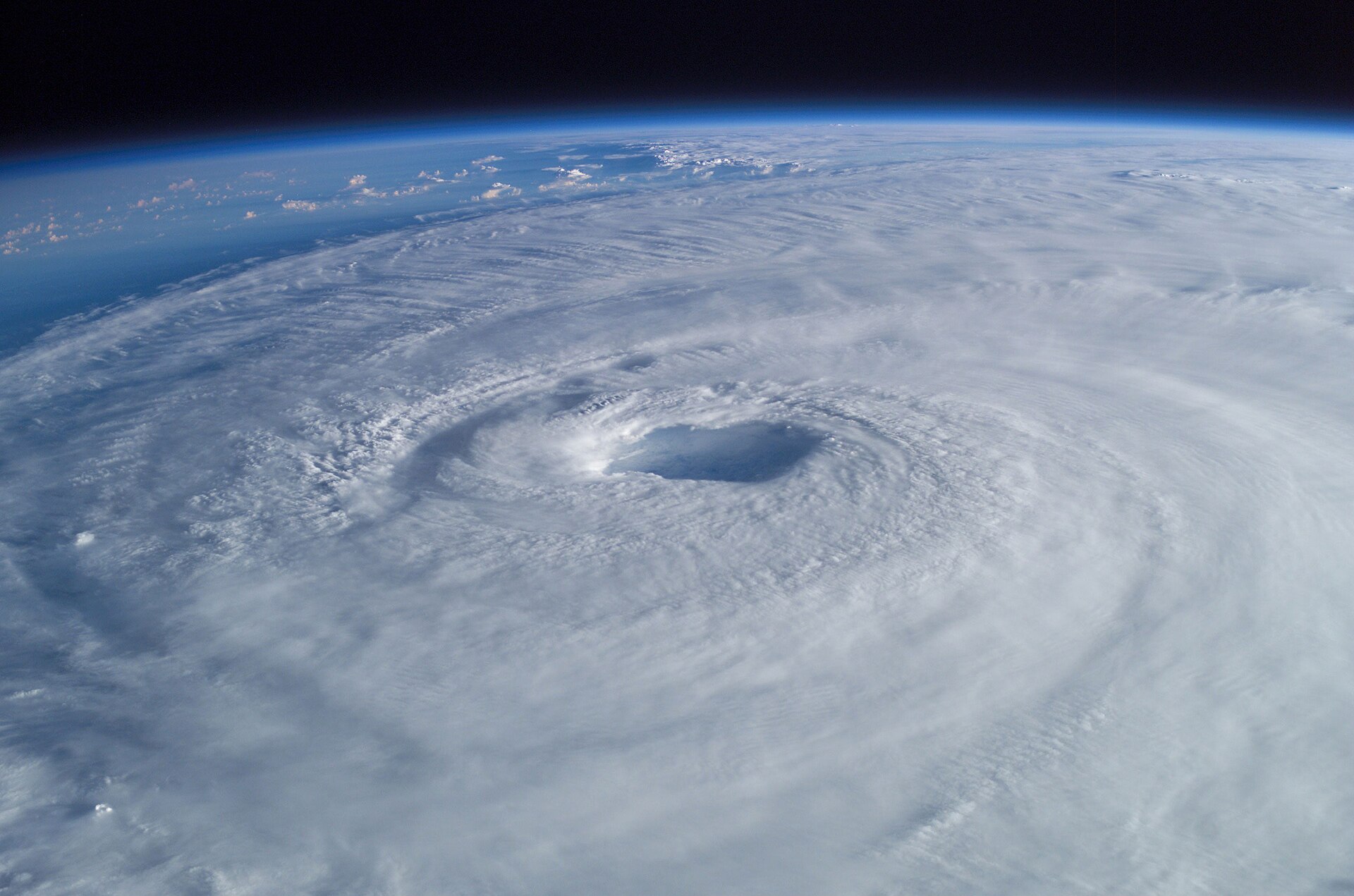 Hurricane Isabel photographed from the International Space Station: a vast spiral of white cloud filling the view, with a clear round eye at its centre.