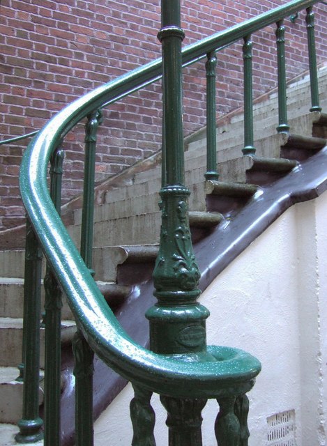 A metal handrail outdoors, metal feels cold because it carries heat away from your hand quickly.