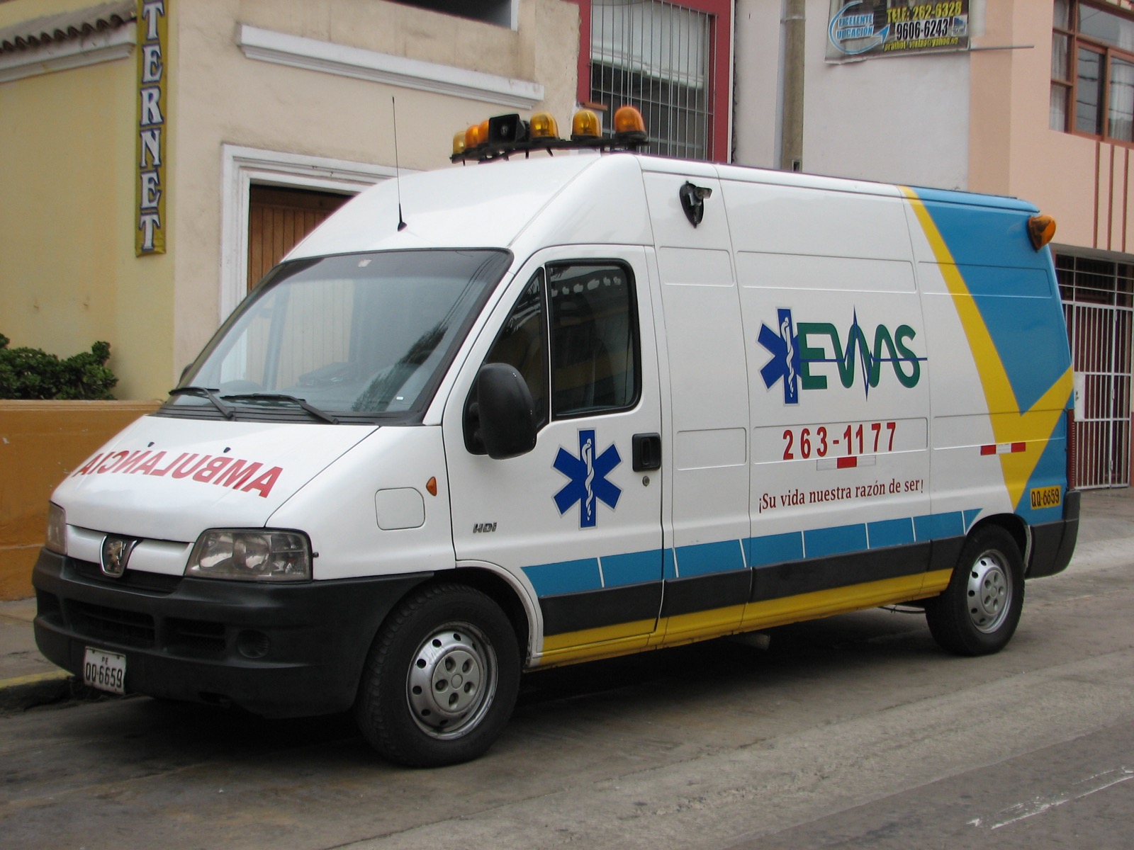 The front of an ambulance with the word AMBULANCIA painted in mirror-writing, so it reads correctly in a driver's mirror.
