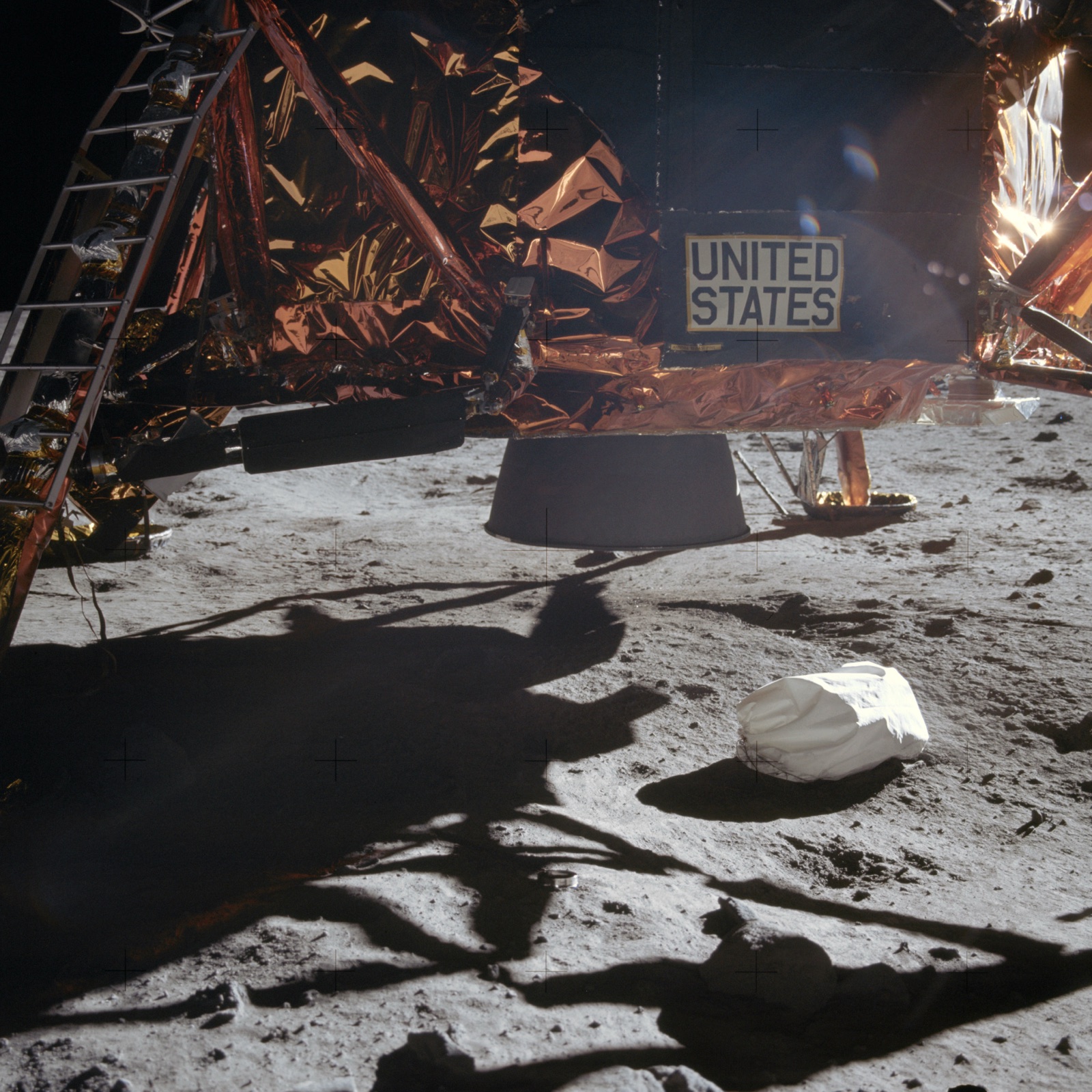 The foot of the Apollo lunar module resting on the grey, dusty surface of the Moon.