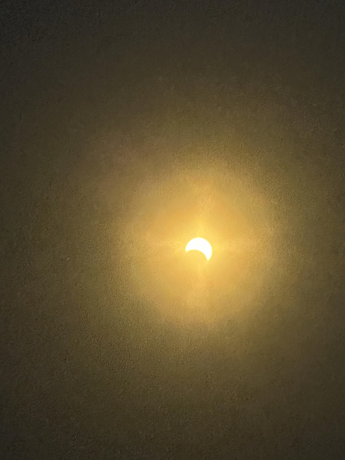 A partial solar eclipse: the Sun reduced to a bright crescent as the Moon covers part of it, the two not quite in a straight line.