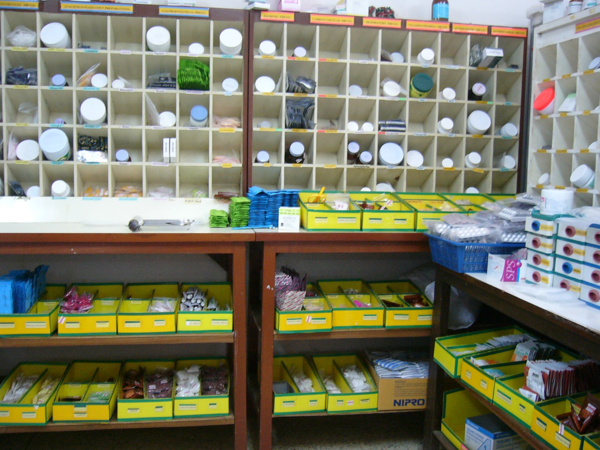 A pharmacy wall of hundreds of labelled pigeonholes and trays full of medicines, not one of which can cure a common cold