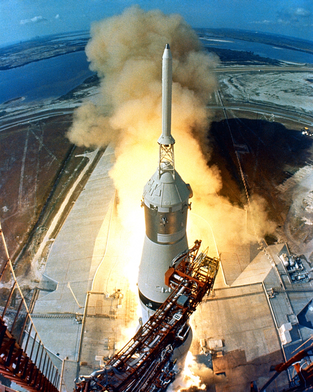 A Saturn V rocket lifting off in a huge cloud of flame and smoke.
