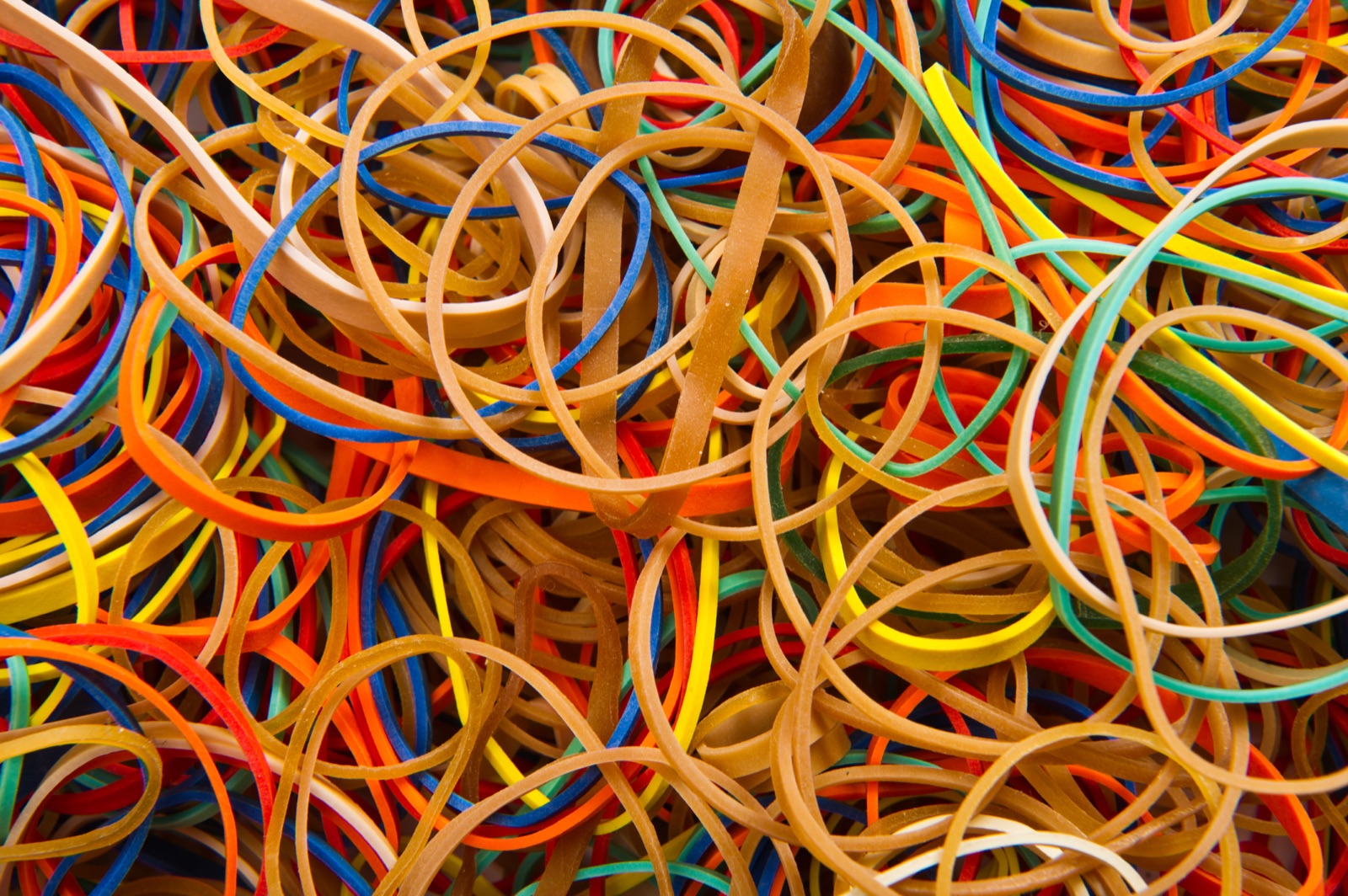 A large pile of colourful rubber bands tangled together