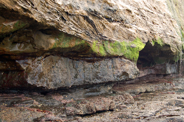 A sandstone cliff where a softer band has been worn back further than the rock above it, leaving a great overhang