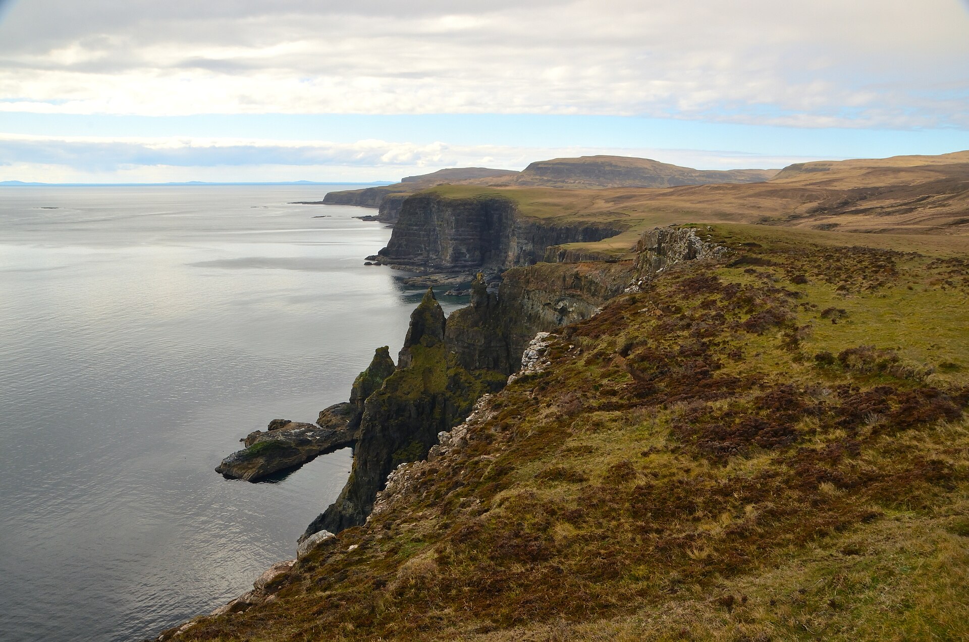 Green sea cliffs on the west coast of Skye dropping away to a calm grey sea