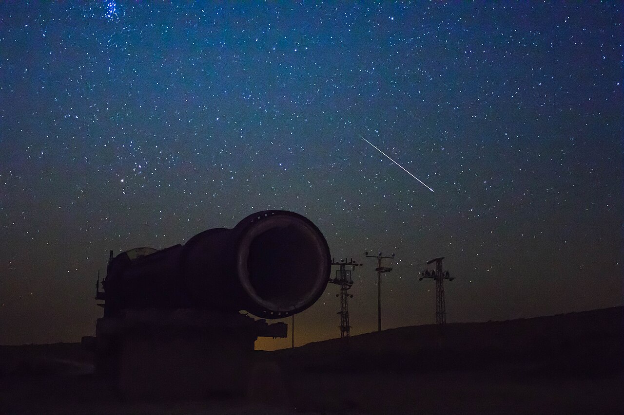 A bright meteor streaking across the night sky during a Perseid shower.