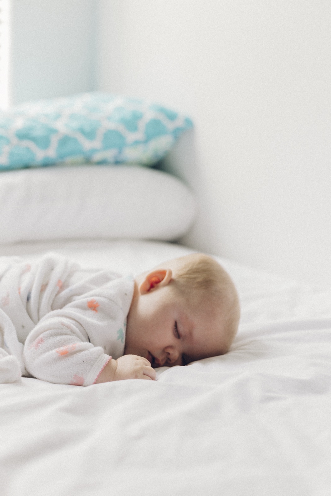 A baby sleeping peacefully on a bed