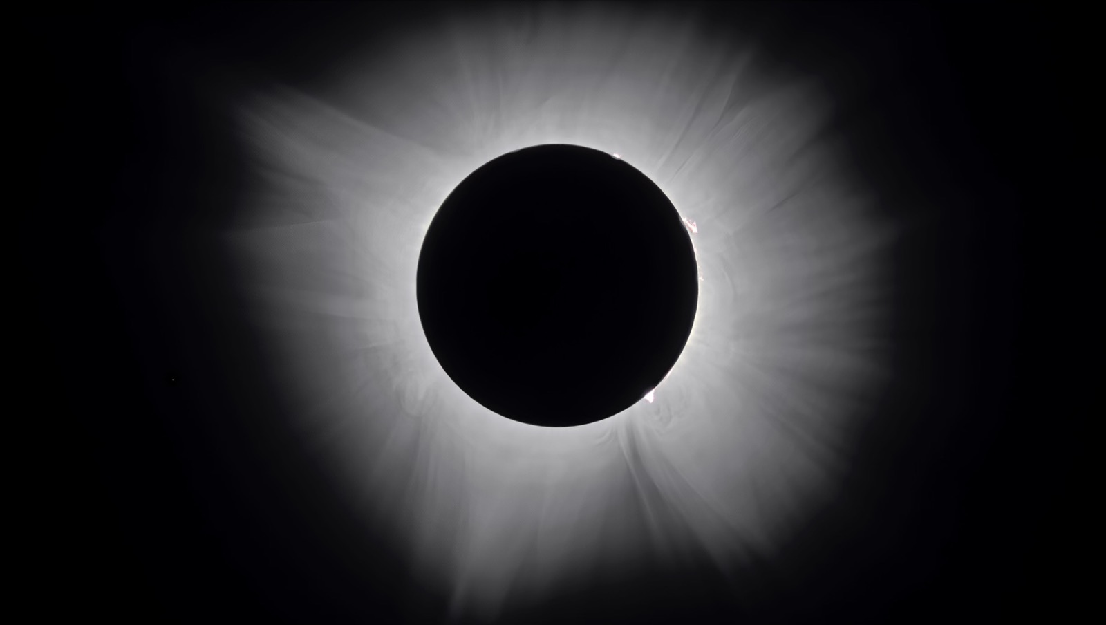 A total solar eclipse: the black disc of the Moon covering the Sun, ringed by the Sun's glowing white corona.