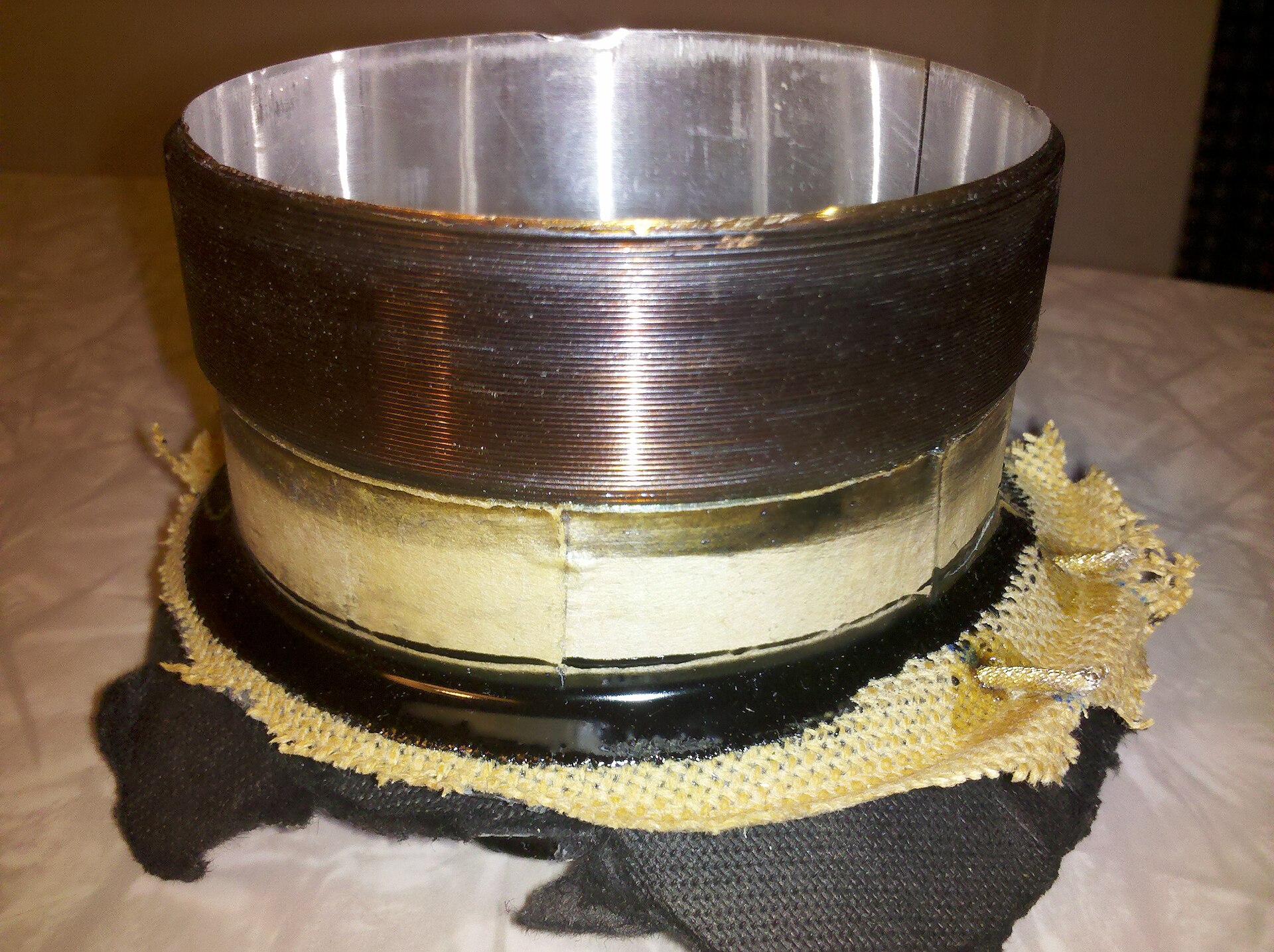 A close-up of a loudspeaker's voice coil, fine copper wire wound many times round a cylinder