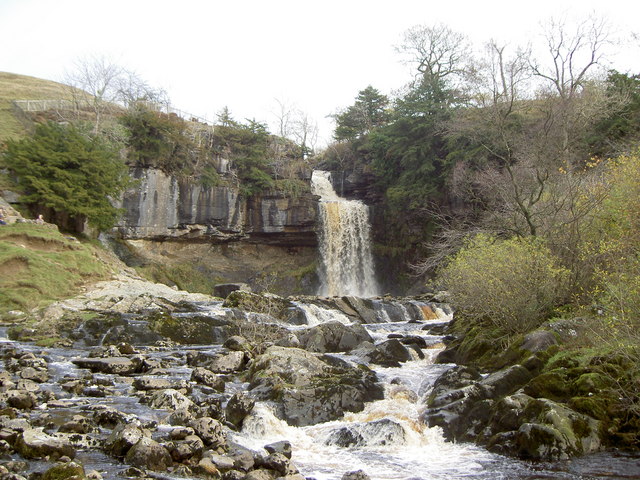Thornton Force waterfall pouring over a hard rock ledge, with softer layered rock cut back underneath it