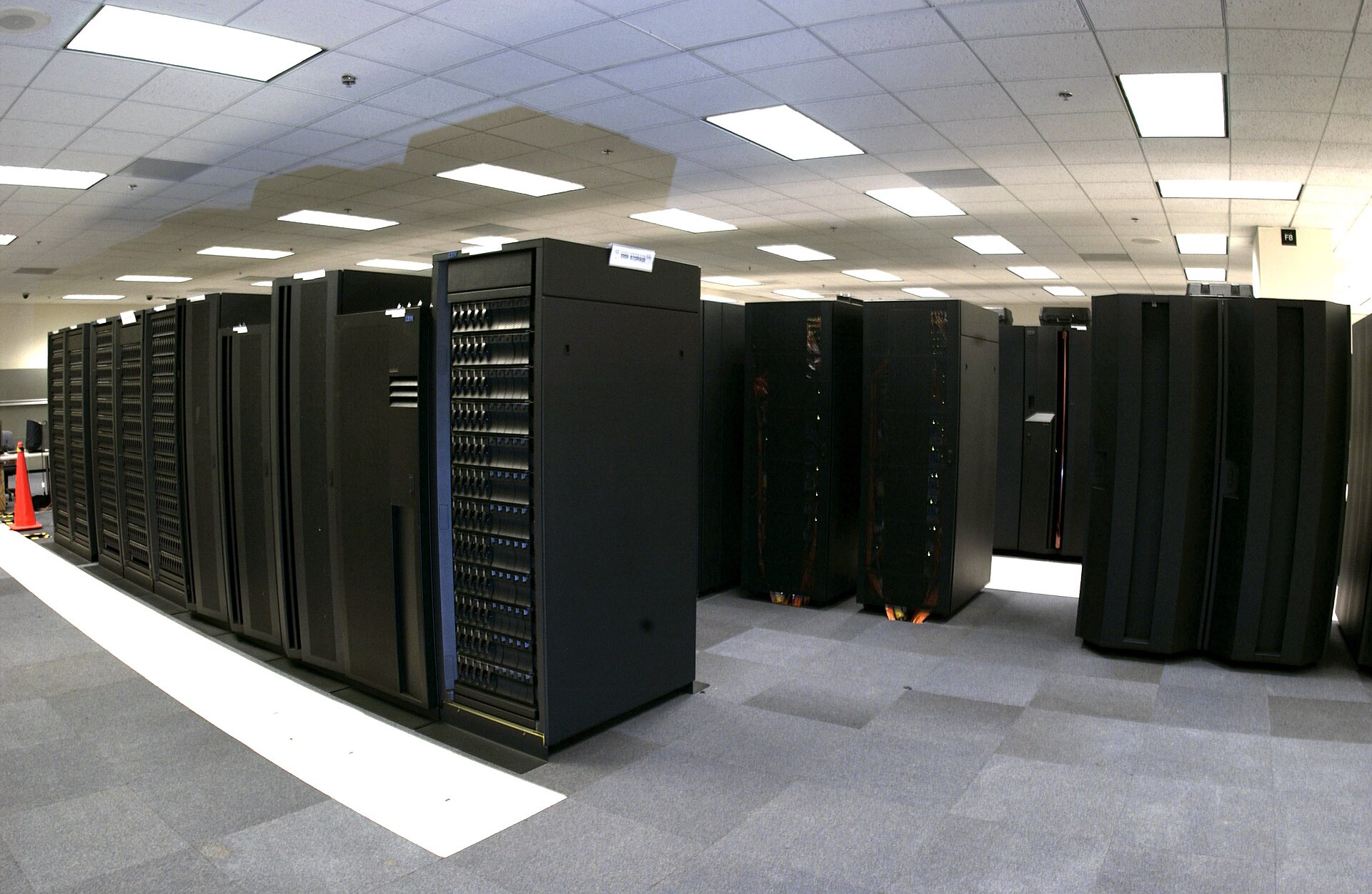 Rows of tall black supercomputer cabinets filling a weather forecasting machine room