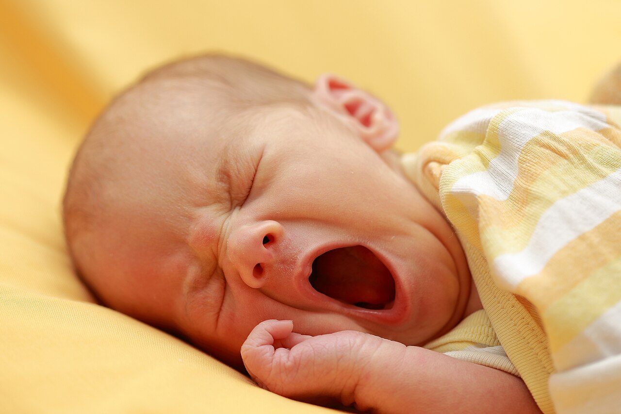 A baby yawning widely